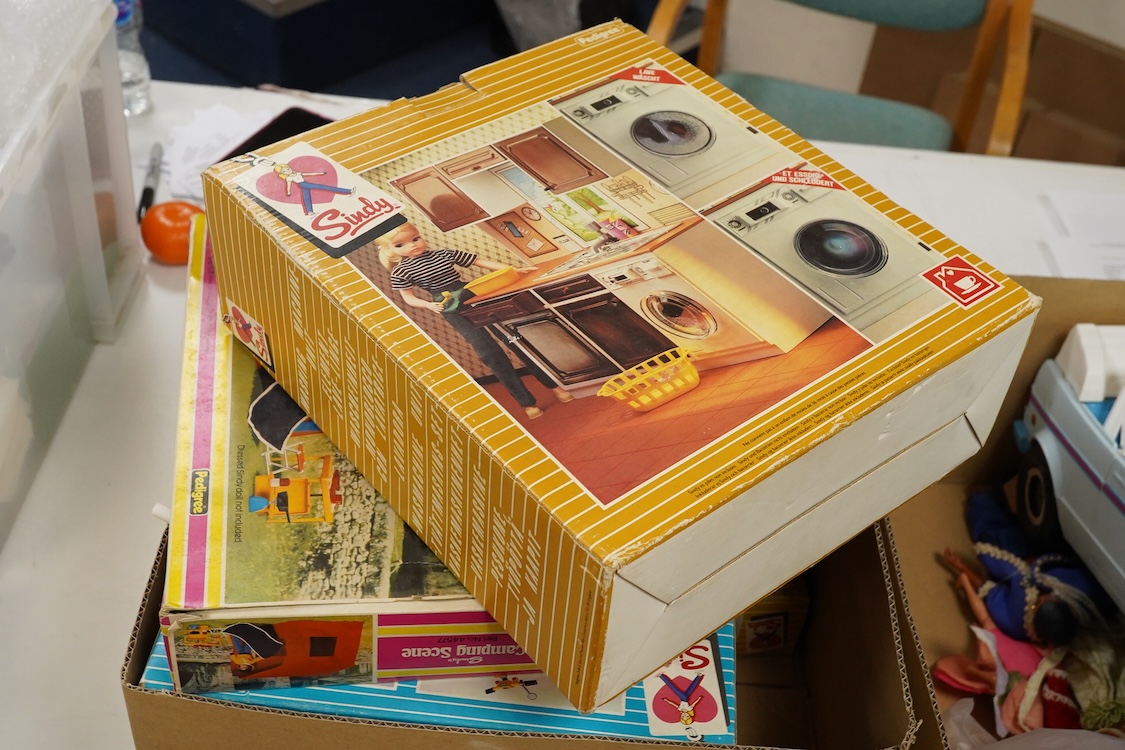 A collection of boxed Sindy doll furniture and accessories, including; a motorcycle (44384), a writing bureau (44512), a hostess trolley, a dressing table, a camping scene, a washing machine unit, together with boxed ite